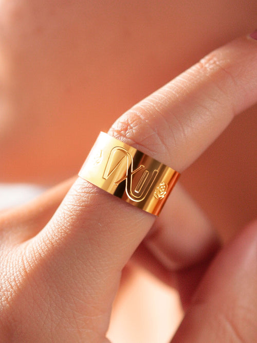 Anillo dorado grabado puesto en el dedo