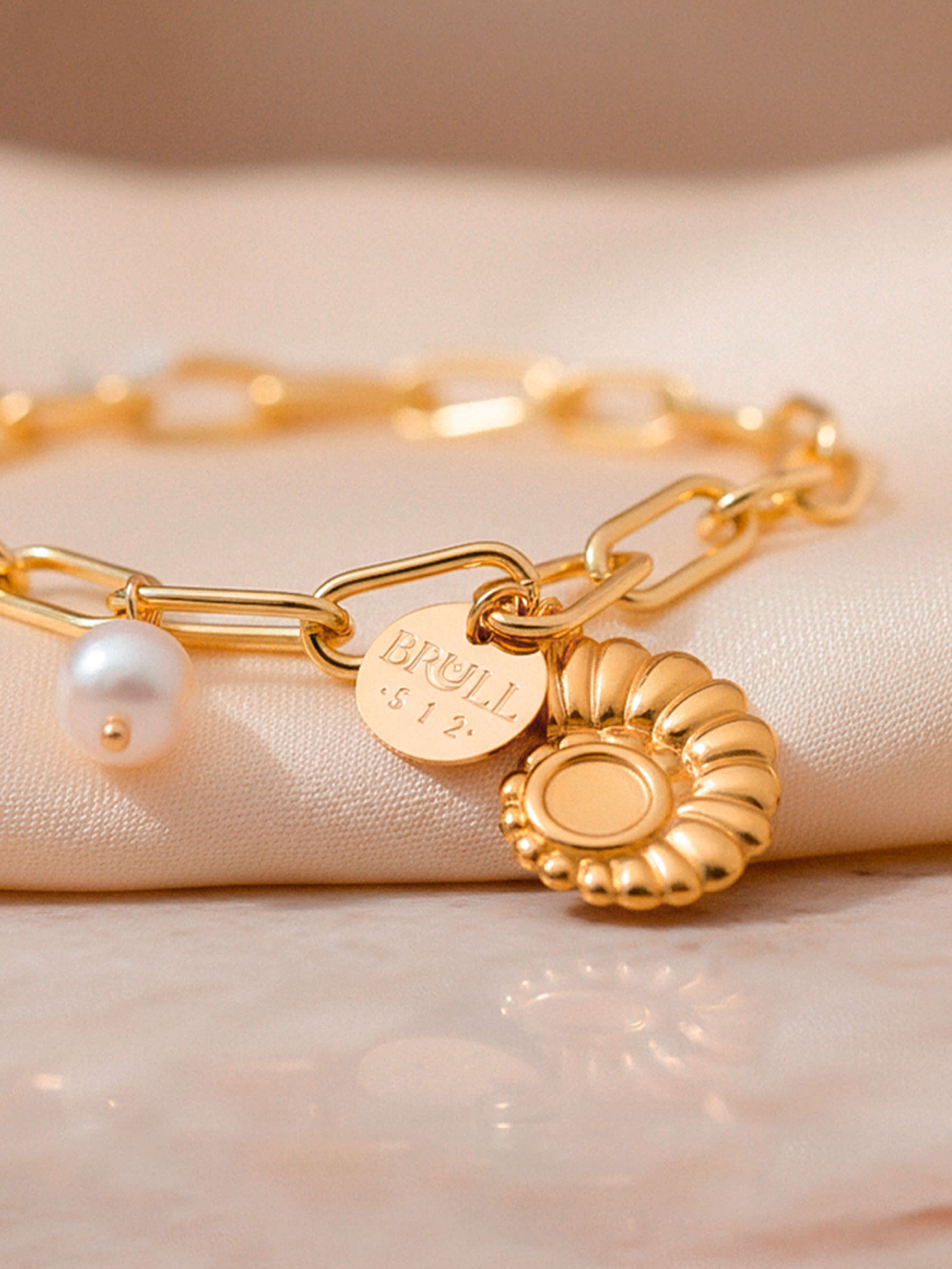 Pulsera dorada de eslabones con dijes y perlas